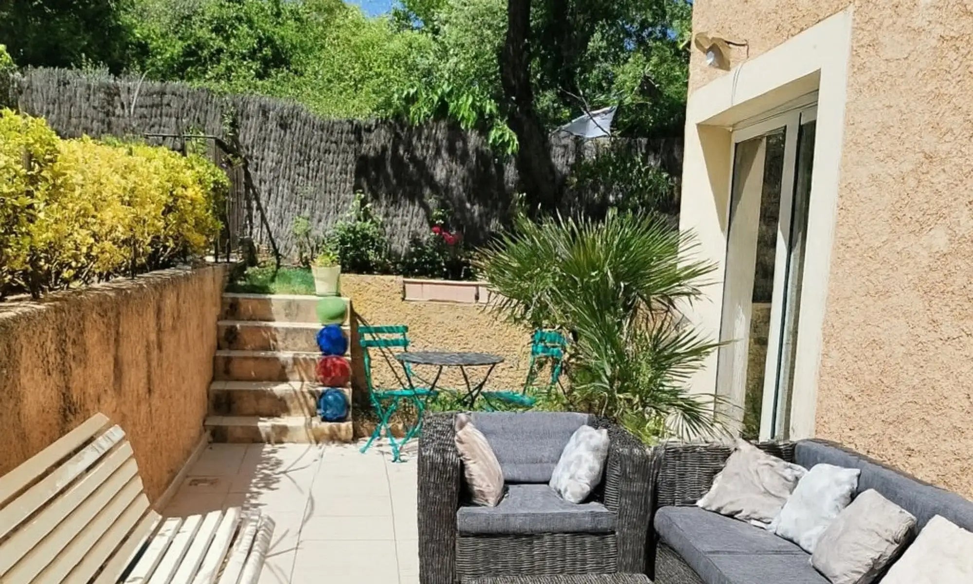 Juego de sofás de exterior de mimbre gris con cojines a juego y almohadas decorativas